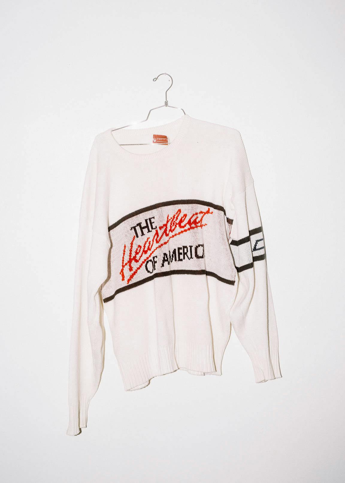 A white long-sleeved shirt with the words "The Heartbeat of America."